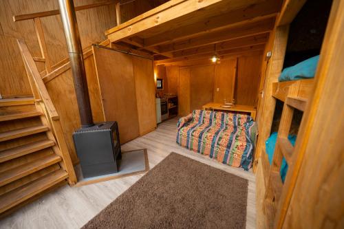 an inside view of a room with a bed and a stove at Andrómeda Lodge in Las Trancas