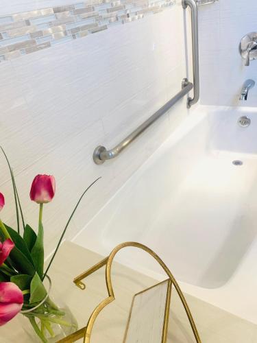 a bathroom with a tub and a vase of flowers at Madison LES Hotel in New York