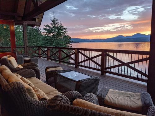 a deck with chairs and a table with a view of a lake at Lodge at Sandpoint in Sandpoint