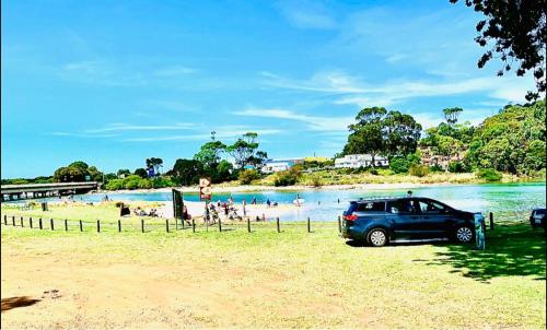 a car parked on a beach next to a body of water at Best Western Burnie - Murchison Lodge in Somerset