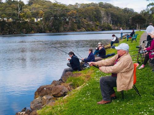 a group of people fishing on the shore of a lake at Best Western Burnie - Murchison Lodge in Somerset