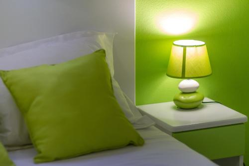 a green bedroom with a bed with a lamp at Les Villas de Boisvin in Le Moule