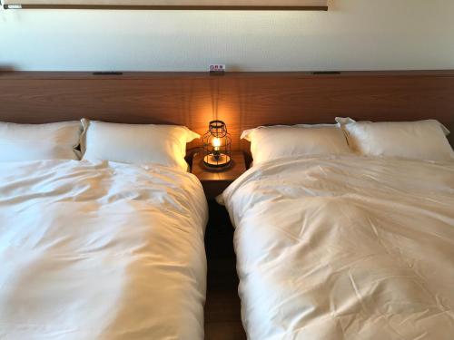 two beds sitting next to each other in a bedroom at 山里の家 in Nanjo