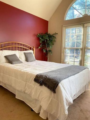 a bedroom with a large white bed with a red wall at NEW Contemporary Chalet 5 Bed/3 Bath in Split Rock in Lake Harmony