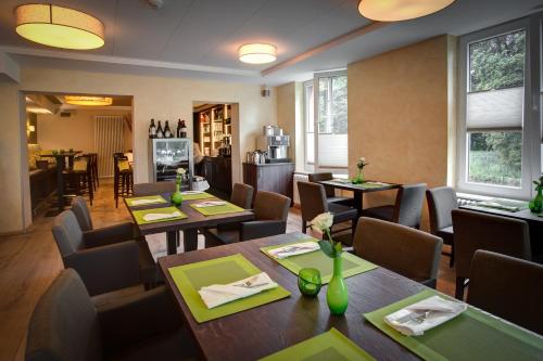 a restaurant with tables and chairs in a room at Weserhotel Schwager in Holzminden