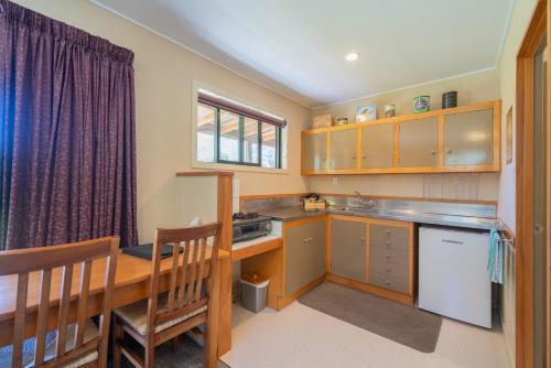 una cucina con armadi in legno, un tavolo e una sala da pranzo di Eglinton Valley Camp a Te Anau Downs
