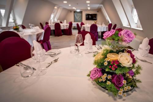 a table with a bouquet of flowers on it at Weserhotel Schwager in Holzminden