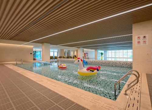a swimming pool with two rubber ducks in the water at Hyatt Regency Guangzhou Zengcheng in Guangzhou