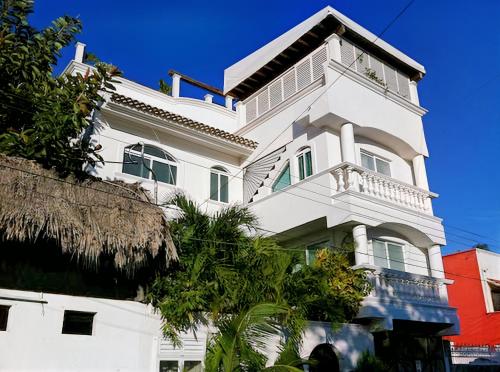 a white building with a balcony on top of it at Mansion Mauresque in Playa del Carmen