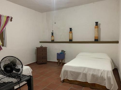 1 dormitorio con cama, silla y estanterías en CASA BONITA, en Oacalco