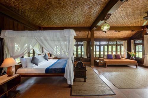a bedroom with a bed with a canopy at Alam Jiwa Ubud in Ubud