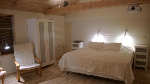 a bedroom with a bed and a chair and lights at Comfortable Bungalow in Ísafjörður