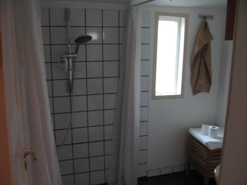 a bathroom with a shower and a window at Comfortable Bungalow in Ísafjörður