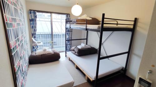 a room with two bunk beds and a window at OD ゲストハウスTSUU小田原 Guest House Tsuu Odawara in Odawara