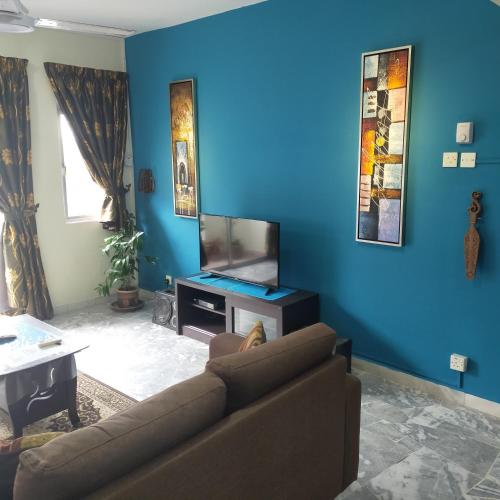 a living room with a couch and a flat screen tv at Relaxing Retreats at Cocobay Apartments in Port Dickson