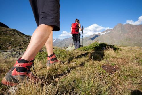 a person walking on a mountain with their shoes on at Hotel Lärchenhof in Kaunertal