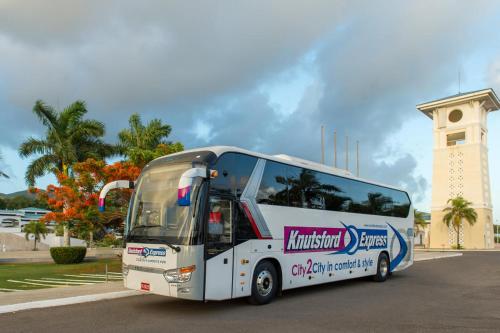 a white bus parked in front of a building at J Ochi ApartHotel in Ocho Rios