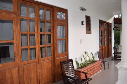 a hallway with wooden doors and chairs in a house at Ceylan Star Guest Inn in Wellawaya