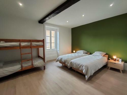1 Schlafzimmer mit 2 Betten und einer grünen Wand in der Unterkunft Gîte Saint-Haon-le-Châtel, 3 pièces, 6 personnes - FR-1-496-254 in Saint-Haon-le-Châtel