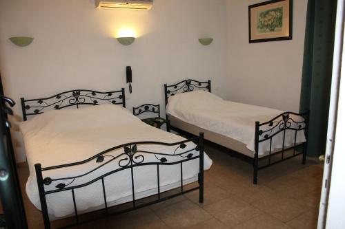 Deux lits jumeaux dans une chambre avec trois piliers dans l'établissement Hotel Restaurant La Camargue, à Salin-de-Giraud