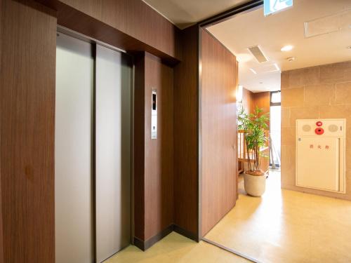a hallway with glass doors in a building at Hotel Iidaya in Matsumoto