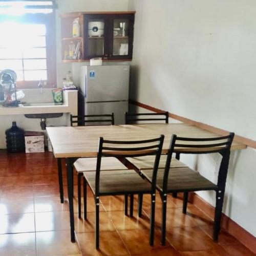 a kitchen with a wooden table and four chairs at SF Homey Yokohama in Cikundul
