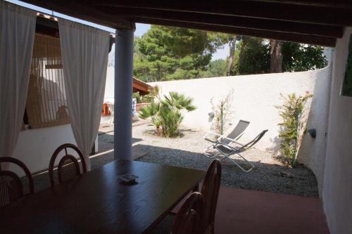 a dining room with a table and chairs on a patio at Villa Crimi in Vulcano