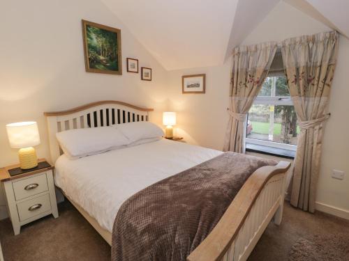 a bedroom with a large bed and a window at Bwthyn Afon River Cottage in Blaenau-Ffestiniog