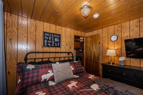 a bedroom with a bed and a clock on the wall at Winterfell Cabin in Rea