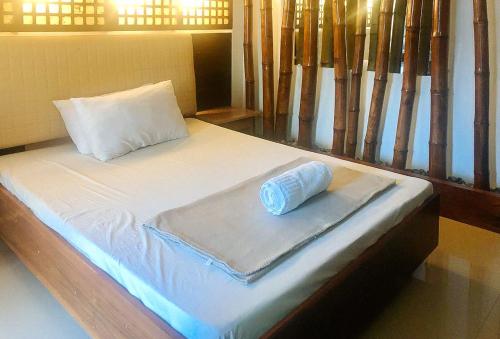 a bed with a rolled up towel on it at E. Moreno Recreation Beach Resort Ilocos Sur in Candon