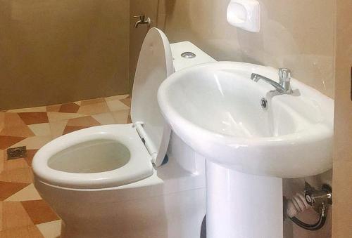 a bathroom with a white toilet and a sink at E. Moreno Recreation Beach Resort Ilocos Sur in Candon