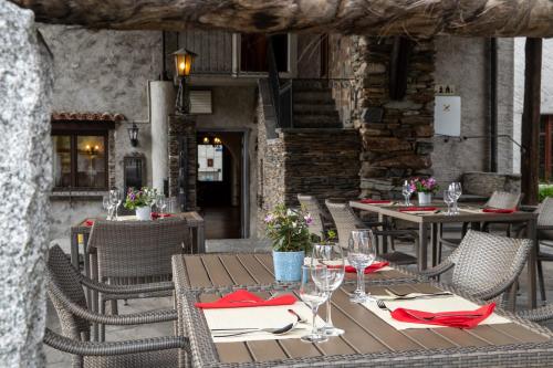 Albergo Pensione San Giorgio في لوزون: مطعم خارجي بطاولات وكراسي بمناديل حمراء