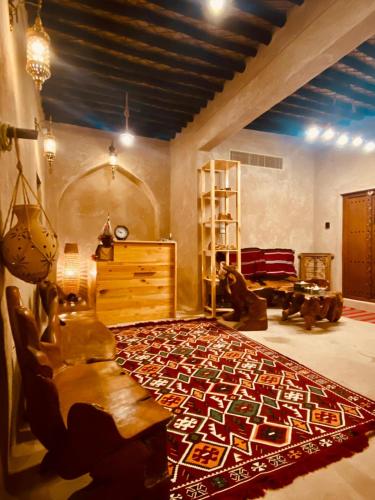 una sala de estar con una alfombra grande en el suelo en Jawharat Alaqar Inn نزل جوهرة العقر, en Nizwa