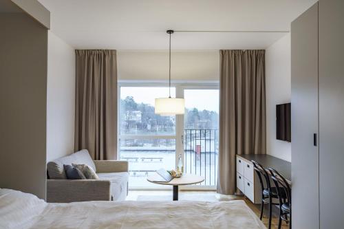 a bedroom with a bed and a living room with a window at Boo Boo Living in Stockholm