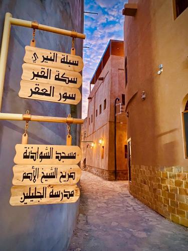 a street sign in an alley with buildings at Jawharat Alaqar Inn نزل جوهرة العقر in Nizwa
