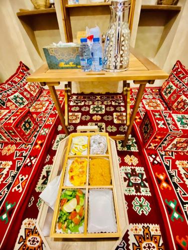 a table with several plates of food on a rug at Jawharat Alaqar Inn نزل جوهرة العقر in Nizwa
