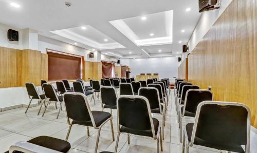 a room with rows of chairs and a podium at Medora Hotel by Rak Rooms in Kozhikode