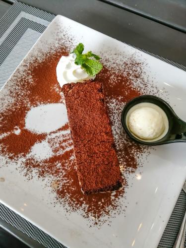 a piece of cake with whipped cream and a sauce at The Cosy Maenam Beach Resort in Mae Nam