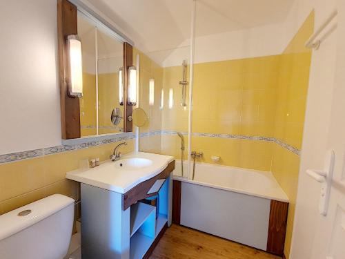 een badkamer met een wastafel, een bad en een toilet bij Residence Le Bocage - Piscine chauffee in Talmont