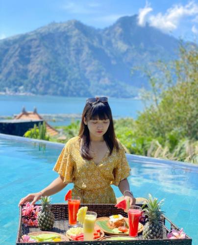 a woman sitting at a table with a tray of food at Villa Danu Kintamani in Kintamani