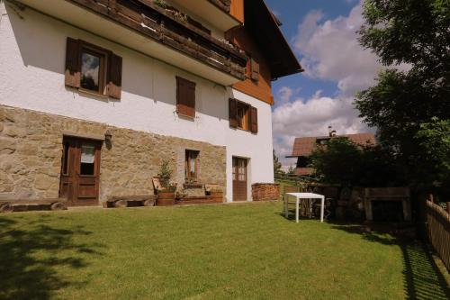 a house with a grass yard in front of it at Appartamento Piller Roner Paola in Sappada