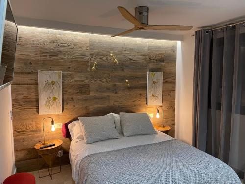 マルベーリャにあるPUERTO BANUS Apartamento COCÓの木製の壁のベッドルーム1室(ベッド1台付)