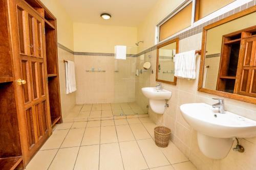 a bathroom with a sink and a toilet and a mirror at CityBlue Creekside Hotel & Suites in Mombasa