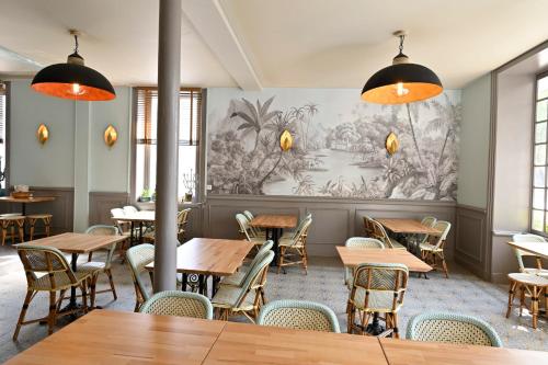 un restaurant avec des tables et des chaises en bois et une fresque murale. dans l'établissement Hôtel Relais du Loir, à La Flèche