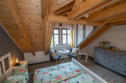 Zimmer im Dachgeschoss mit einem Bett und einem Tisch in der Unterkunft Gästehaus am Stadttor in Naumburg