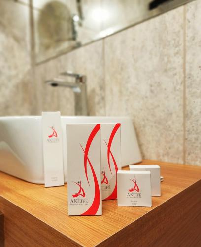 three white and red signs on a counter in a bathroom at AK LİFE HOtEL in Ankara