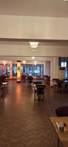 een grote kamer met tafels en stoelen en een kroonluchter bij AK LİFE HOTEL&SUIT in Ankara