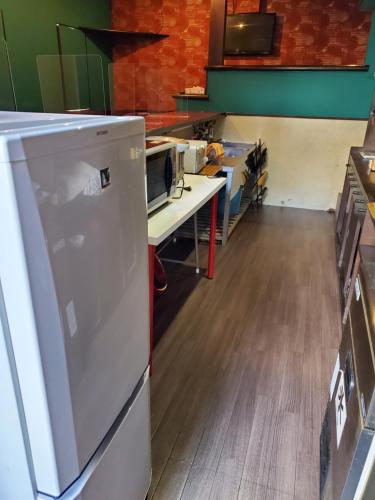a kitchen with a white refrigerator and a desk at Naoshima Kowloon in Naoshima