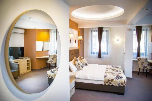 a hotel room with a bed and a mirror at Hotel & Restaurant Ponte Bianco in Vranje