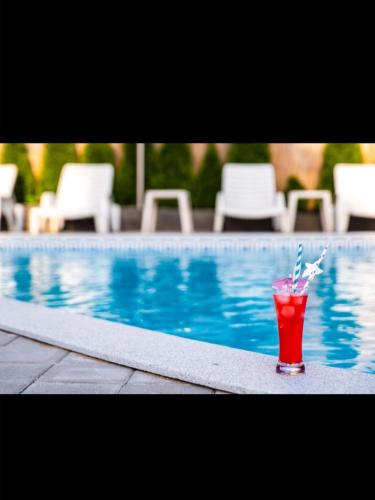 a drink sitting on the edge of a swimming pool at Smestaj Milovanovic in Soko Banja